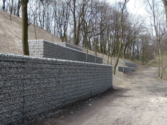 Reinforced soil retaining wall with steel mesh and stone fill facing.JPG